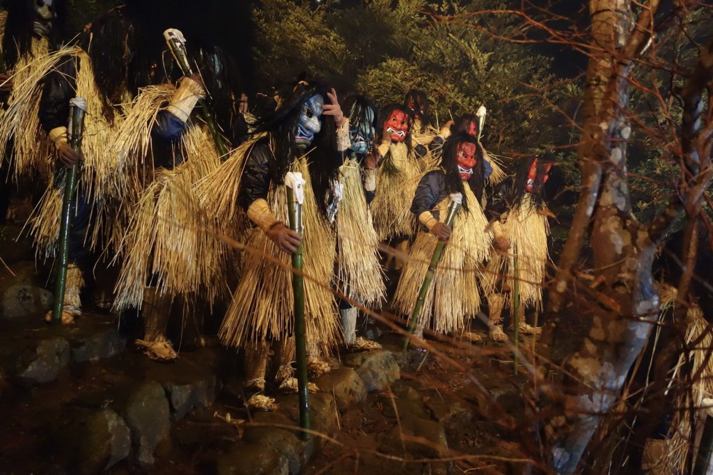 Masked Namahage in straw capes gathered at night during the Namahage Sedo Festival in Oga, Akita